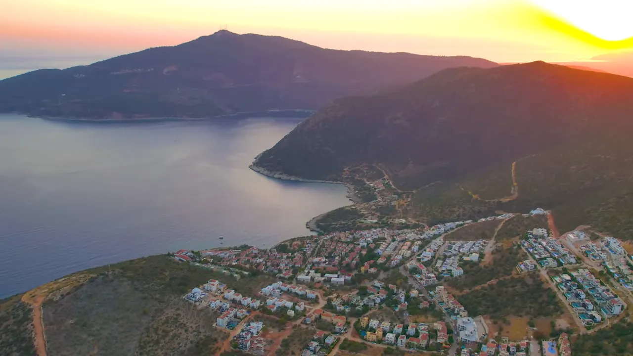 Wide aerial panorama of Kaş and Kalkan coastline at sunset with mountains, bay and clustered seaside homes