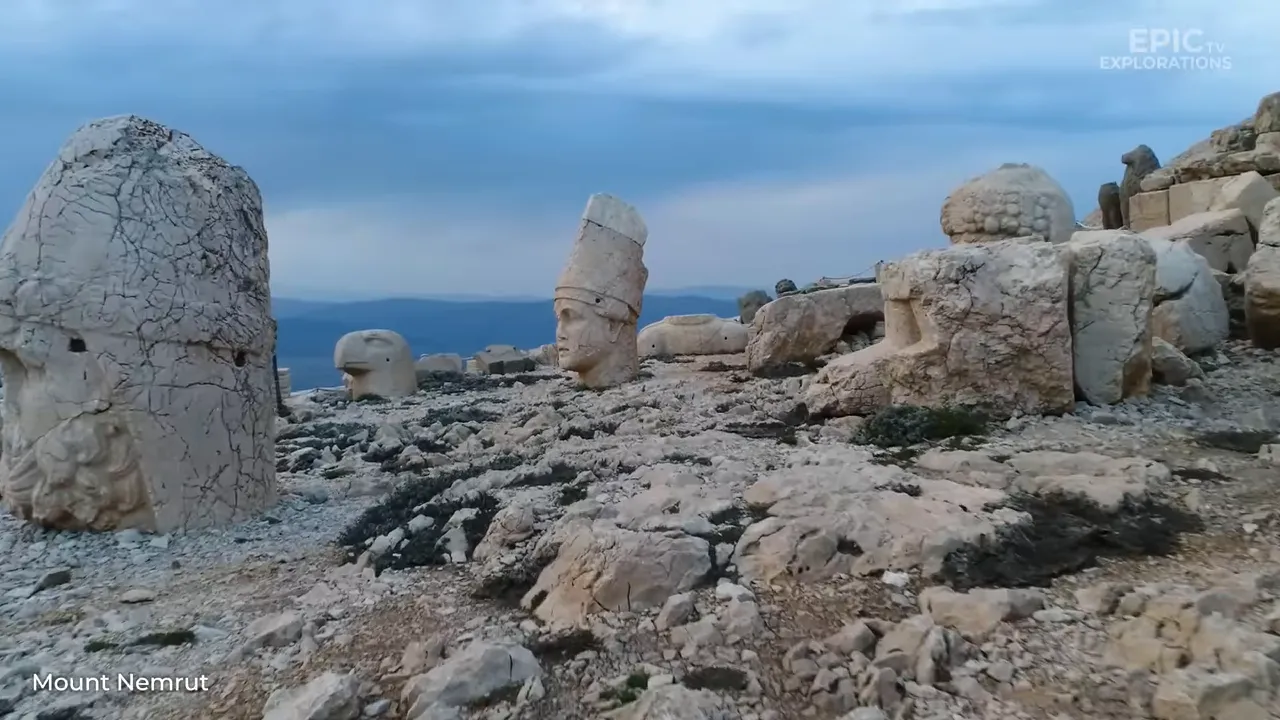 Panoramic view of Mount Nemrut showing multiple colossal carved stone heads resting on the rocky summit.