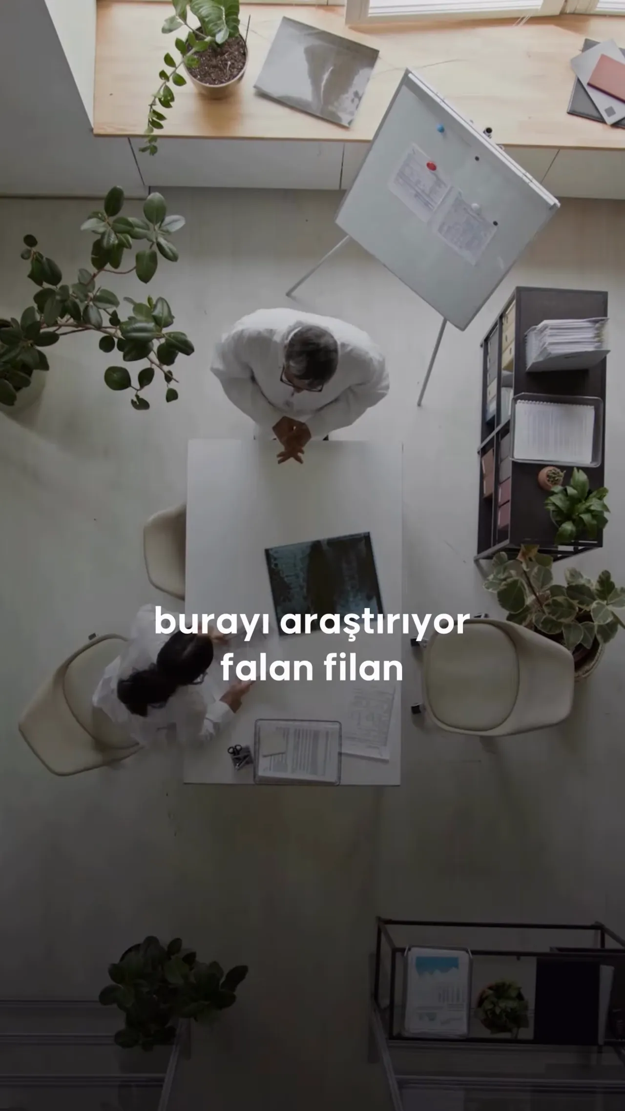 Masa &uuml;zerinde planlar, haritalar ve iki kişinin etrafında tartıştığı ofis &ccedil;alışması