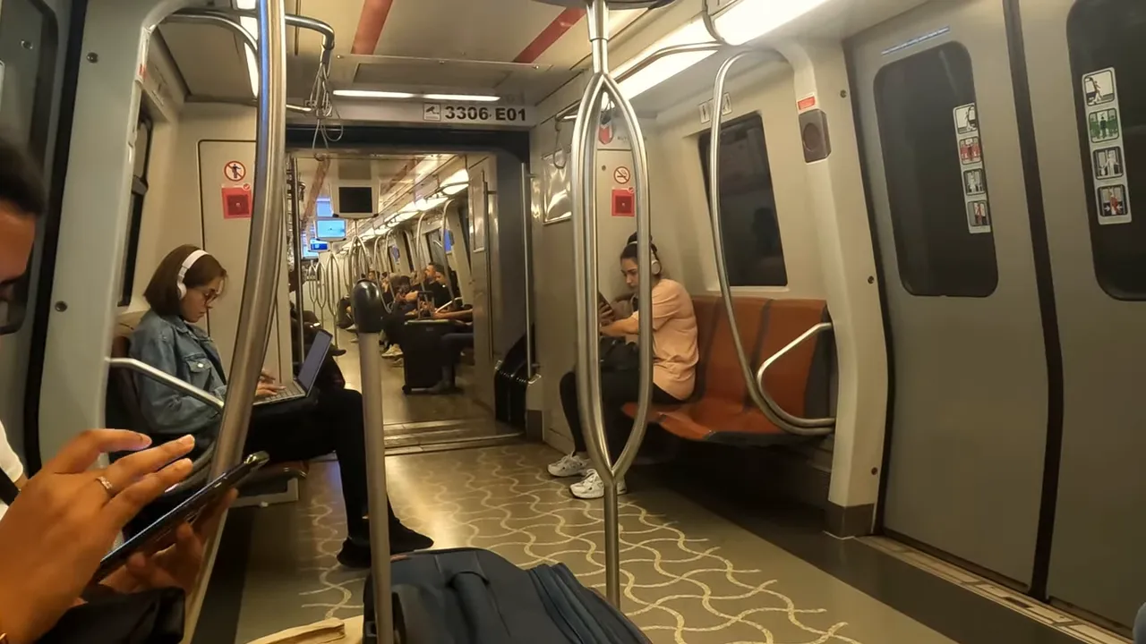 Interior of an Istanbul metro carriage with seated passengers and handrails