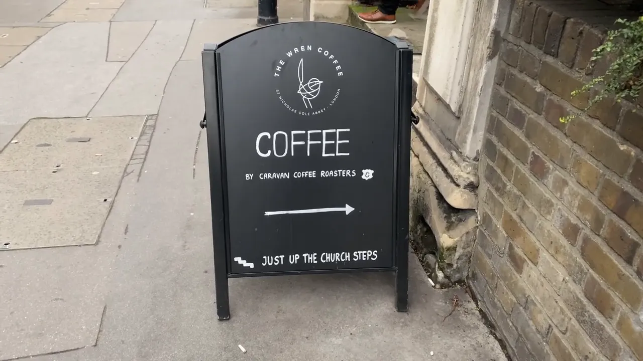 The Wren Coffee tabelası, kilise basamaklarına işaret ederken