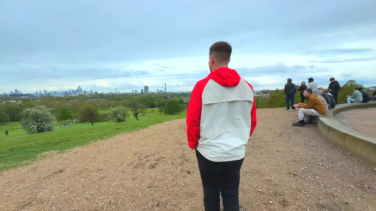 View from Primrose Hill overlooking the London skyline with people at the viewpoint
