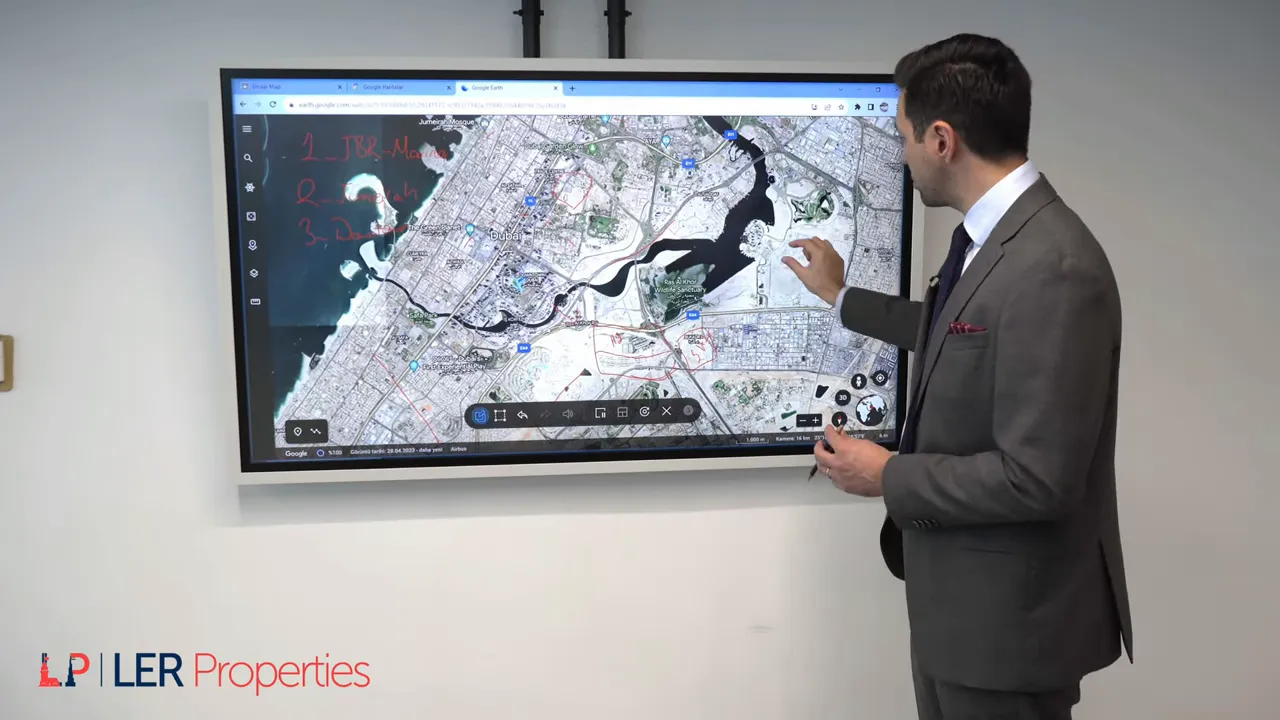 konuşmacı ekranda Dubai haritasında Creek Harbour adasını işaret ediyor