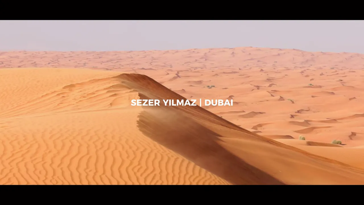 Geniş Dubai &ccedil;&ouml;l&uuml; ve kum tepeleri, ekran &uuml;zerinde video başlığı g&ouml;r&uuml;nen kare.