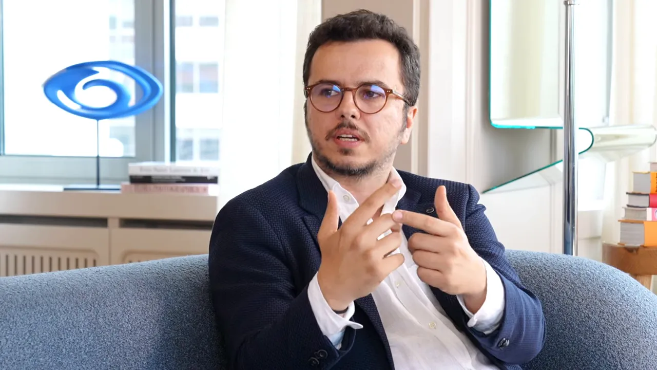 A&ccedil;ık ofis ortamında oturan uzman, parmakla işaret ederek s&uuml;reci a&ccedil;ıklıyor