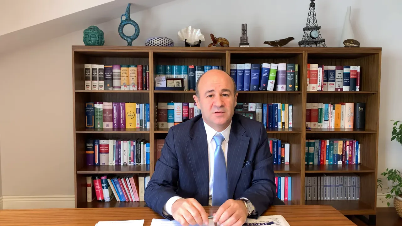 Ofiste kitaplık ve masa &ouml;n&uuml;nde konuşan uzman, kentsel d&ouml;n&uuml;ş&uuml;m başvuru rehberi.