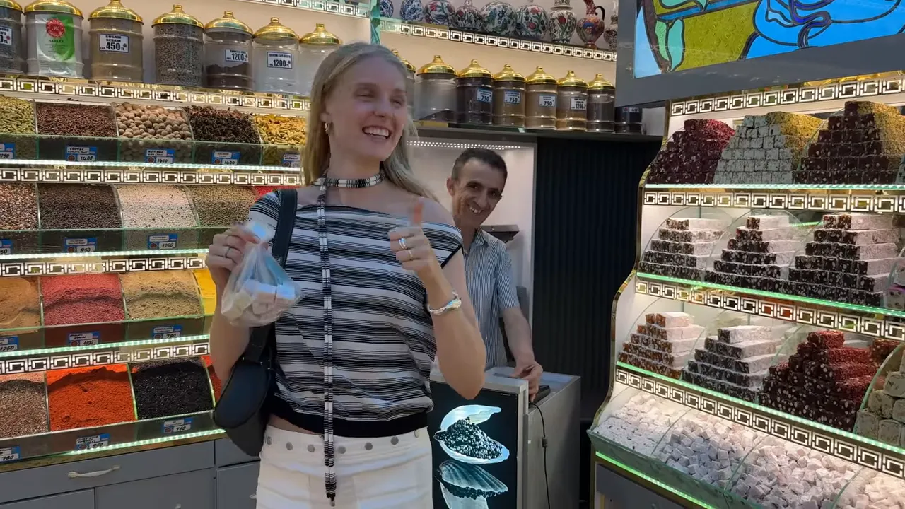 Shop display with stacked Turkish delight and spice jars, with a person holding a small bag of sweets