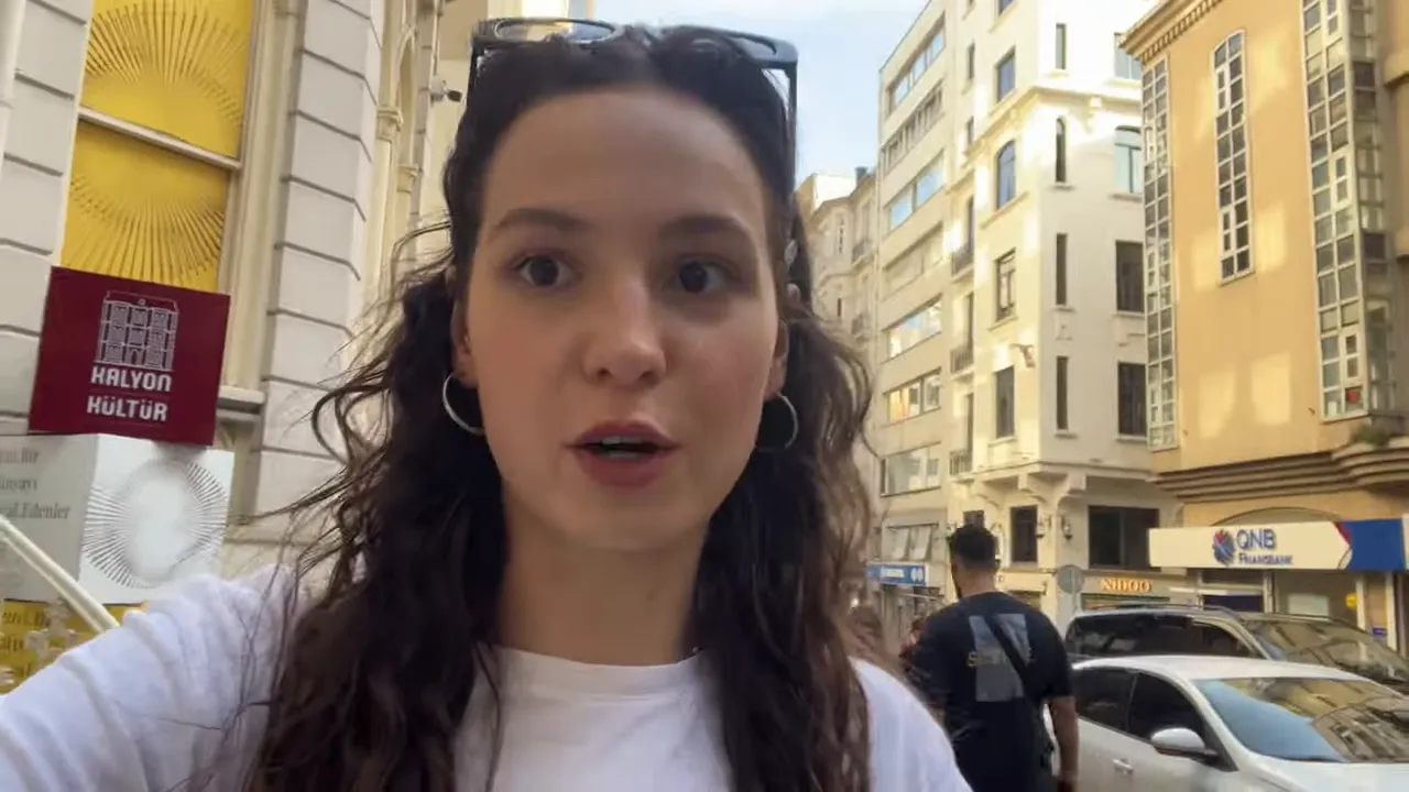 vlogger walking on a narrow Istanbul street with buildings, pedestrians and storefront signs