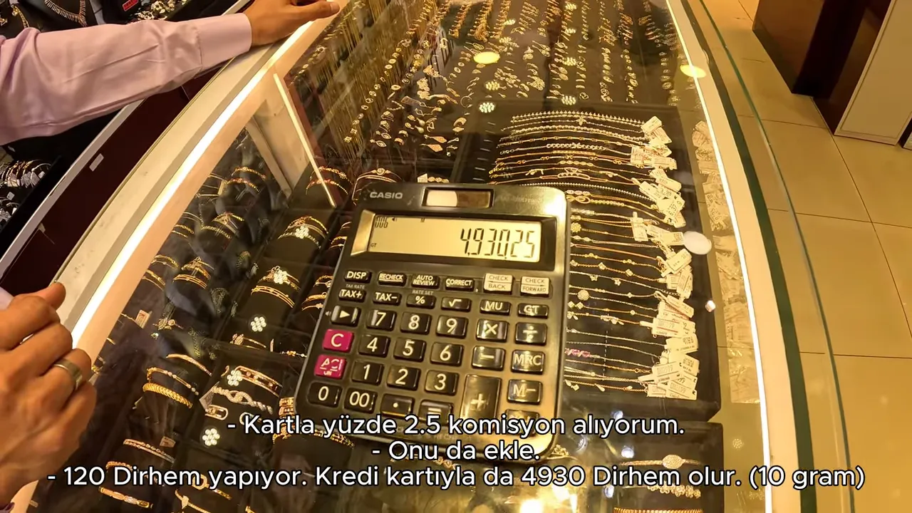 Tezgâh üzerinde hesap makinesinde 4930.25 gösteren ekran ve altın takılar