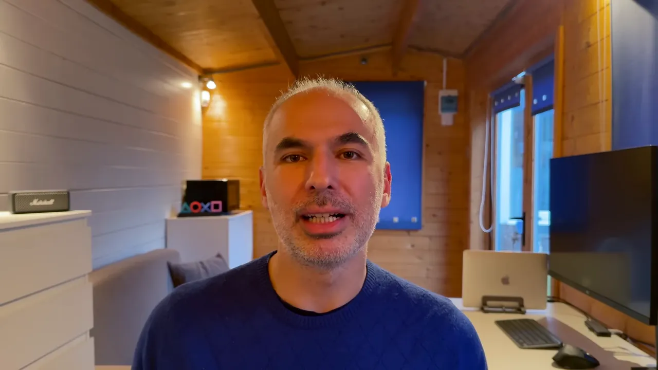 Konuşmacı ev ofisinde, net ve iyi aydınlatılmış bir karede konuşuyor.