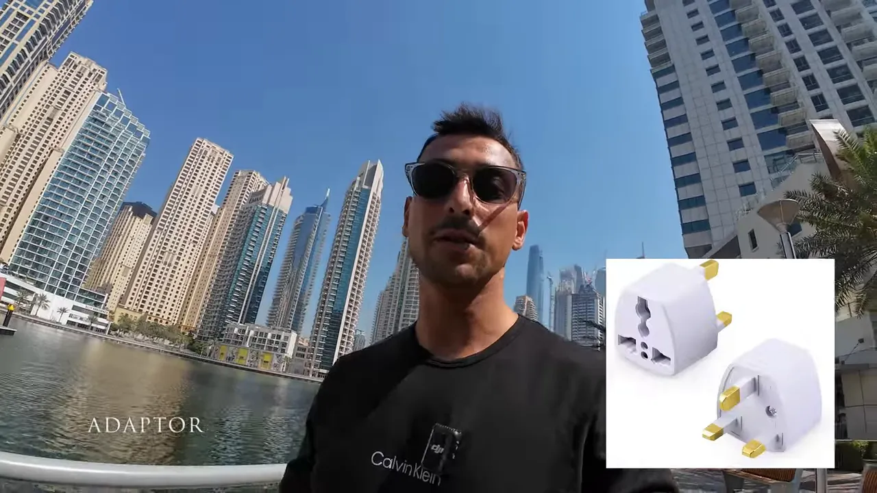 Dubai marina &ouml;n&uuml;nde vlog yapan kişi ile sağ alt k&ouml;şede beyaz priz adapt&ouml;r&uuml; resmi