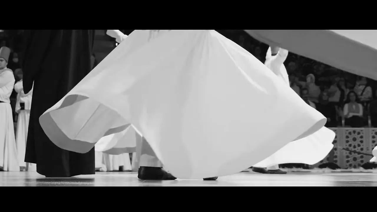 black and white close-up of whirling dervishes' skirts and feet on stage during the Sema ceremony