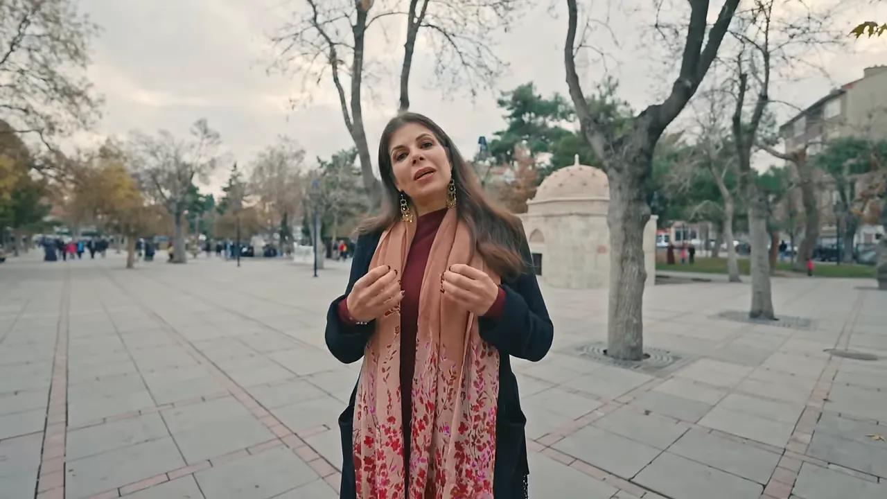 Presenter explaining Rumî's meeting with Shams in Konya's public square
