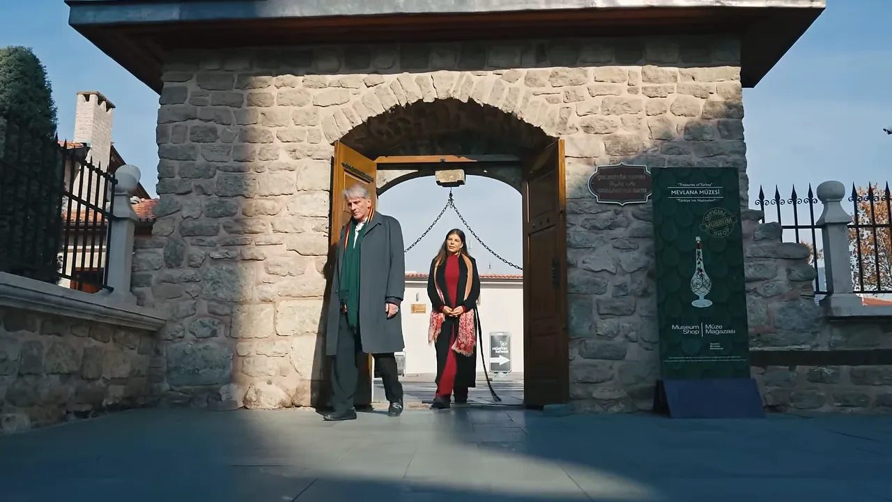 Visitors passing through the stone entrance gate of the Mevlana Museum in Konya