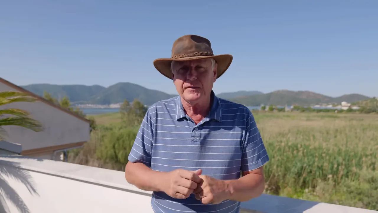 Clear shot of the presenter on a terrace with coastal landscape behind him, ideal for introducing living-cost topics.