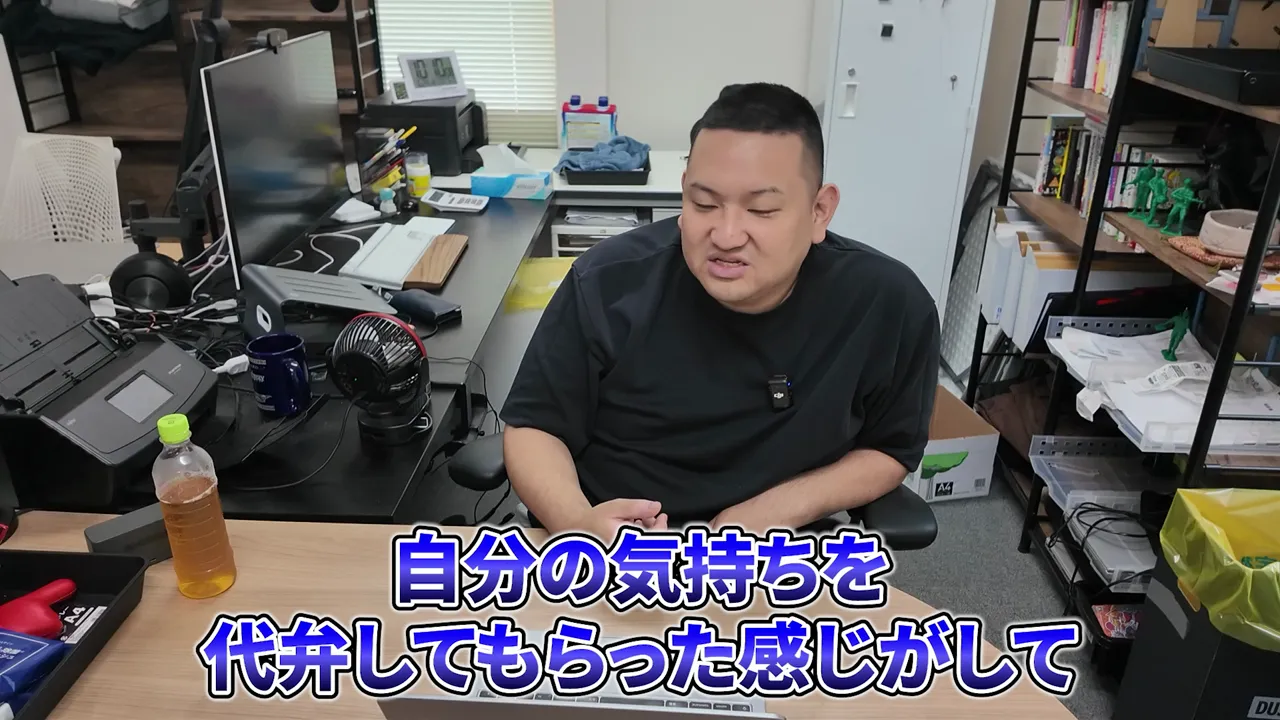 机の前に座る男性と自分の気持ちを代弁してもらったという字幕
