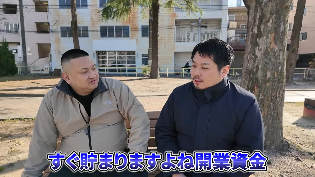 屋外で会話する男性2人、ベンチ越しのインタビュー風景