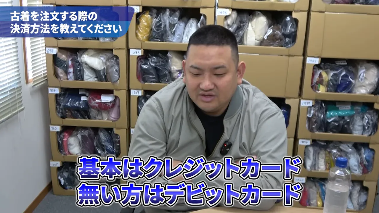 画面下に大きく「基本はクレジットカード　無い方はデビットカード」と表示されたインタビュー画像