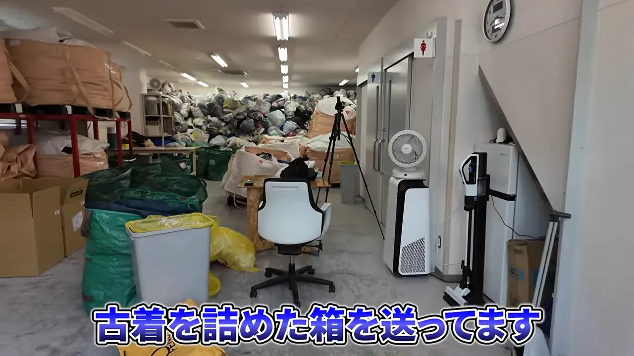 古着の袋と段ボールが並ぶ倉庫内の仕分け作業スペース