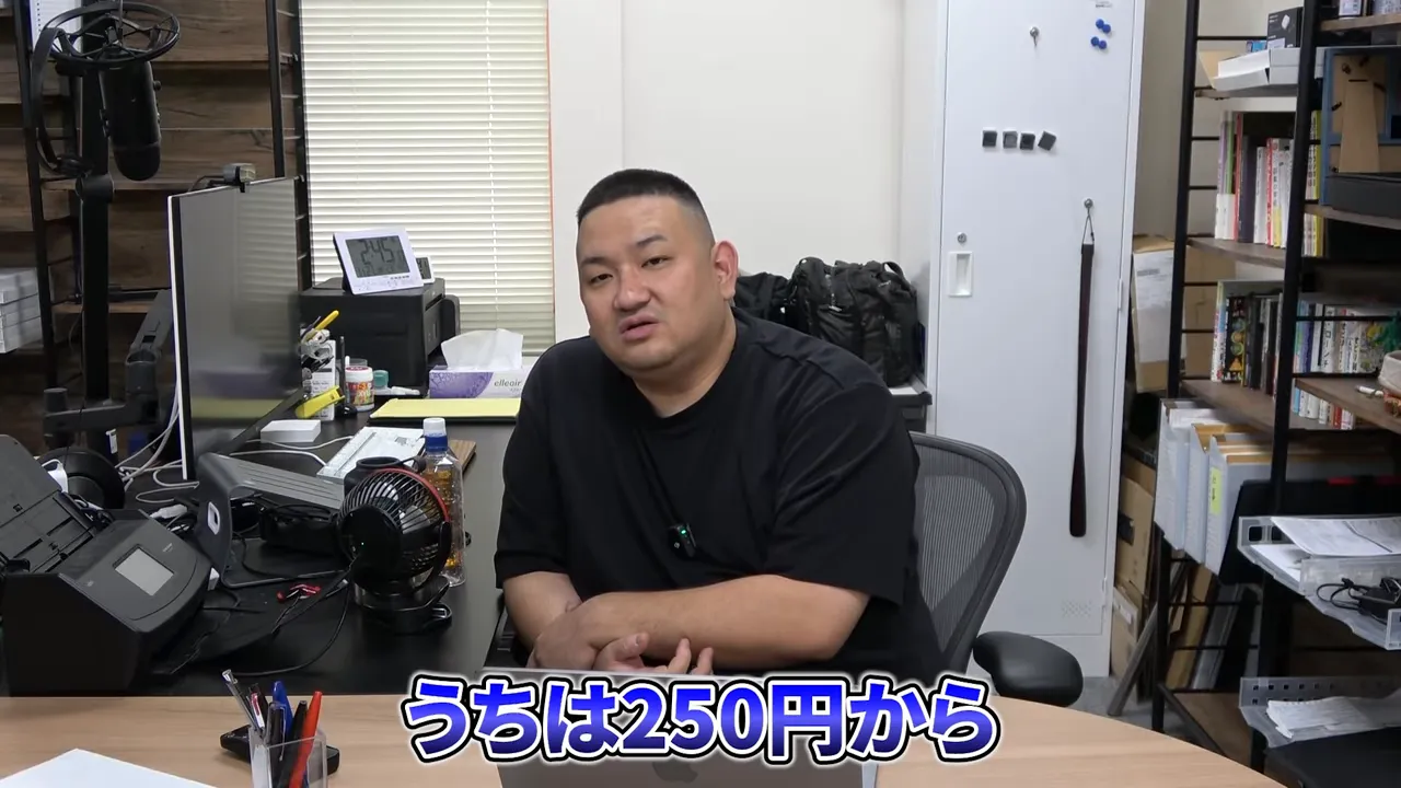 デスクに座って話す男性と「うちは250円から」のテロップ