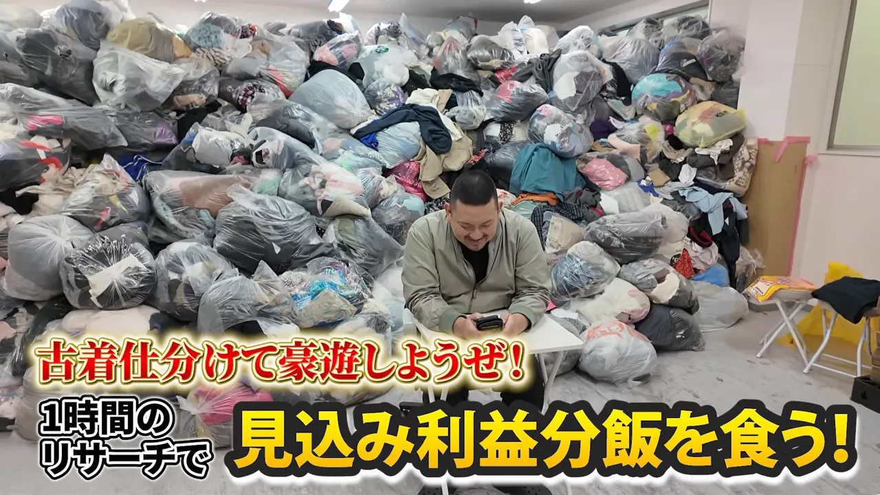 天井近くまで積まれた大量の古着袋と仕分け作業をする人物