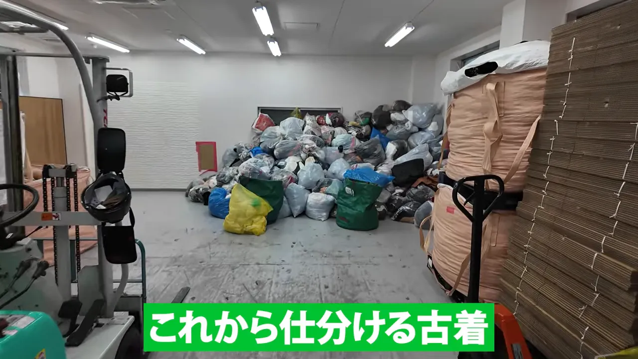 フォークリフトと大量の古着袋がある倉庫の奥