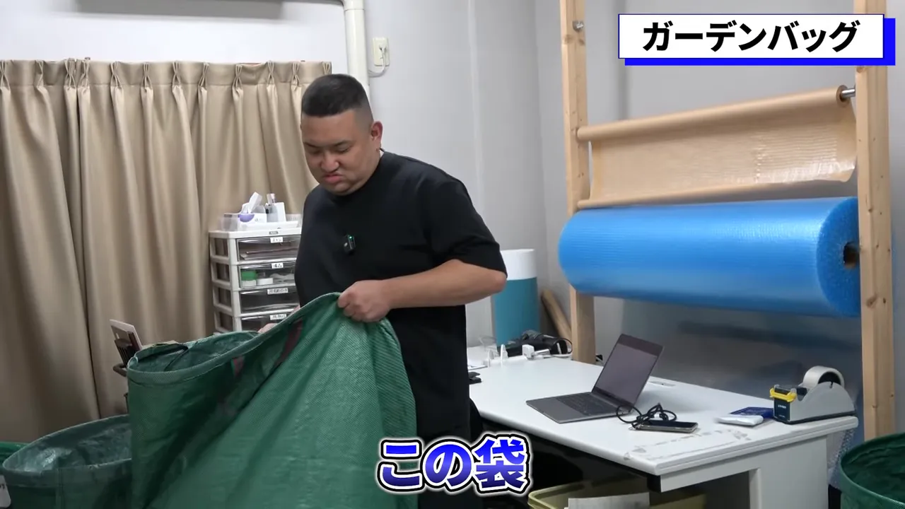 緑色のガーデンバッグを広げて持つ様子、仕分け用の大きな袋が分かる写真