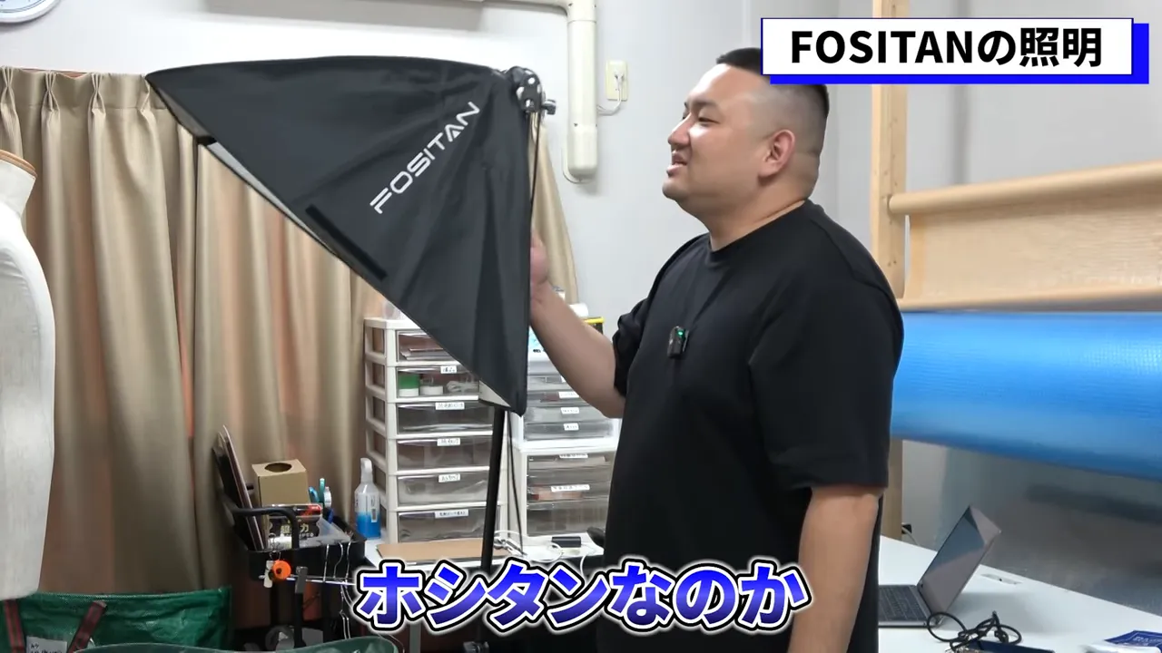 人物がFOSITANのソフトボックスを調整している、撮影用照明のクローズアップ写真。ライトの形状と位置がわかる。