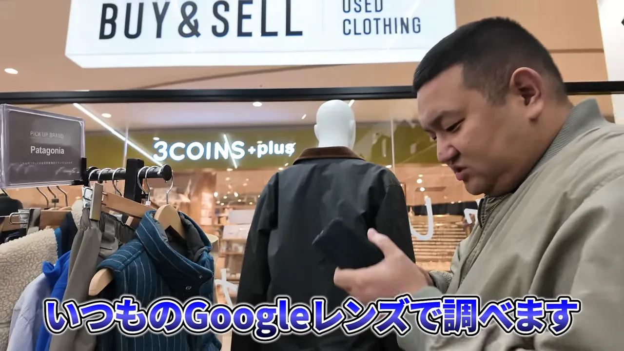 スマホを使って商品を撮影しながらリサーチする男性と店内のマネキン・ラック