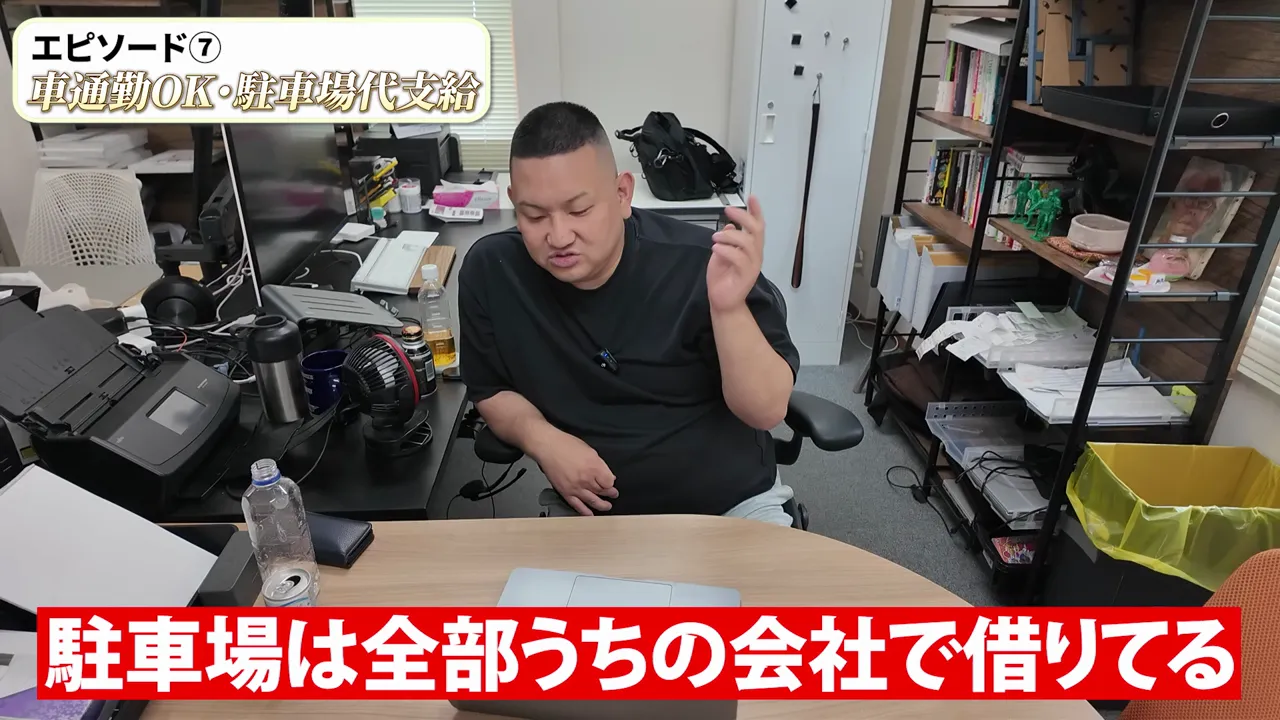 机の前に座る伊藤社長と駐車場は会社で借りていることを示す字幕