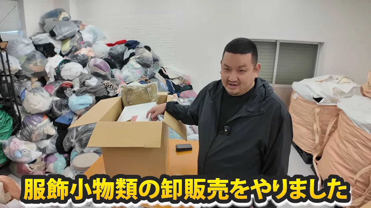 古着卸の倉庫で段ボールの中身を確認する人物