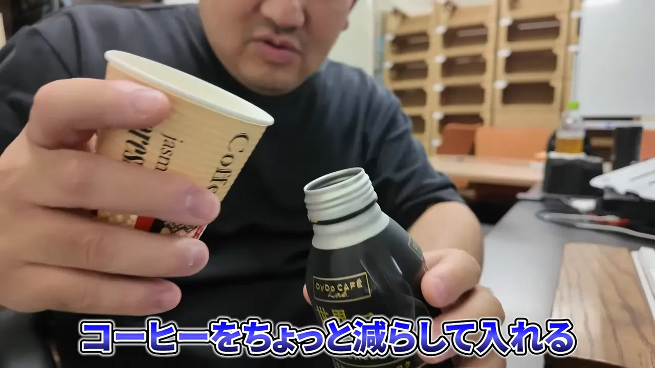 紙コップの中身をアイスコーヒーのボトルへ注いでいる