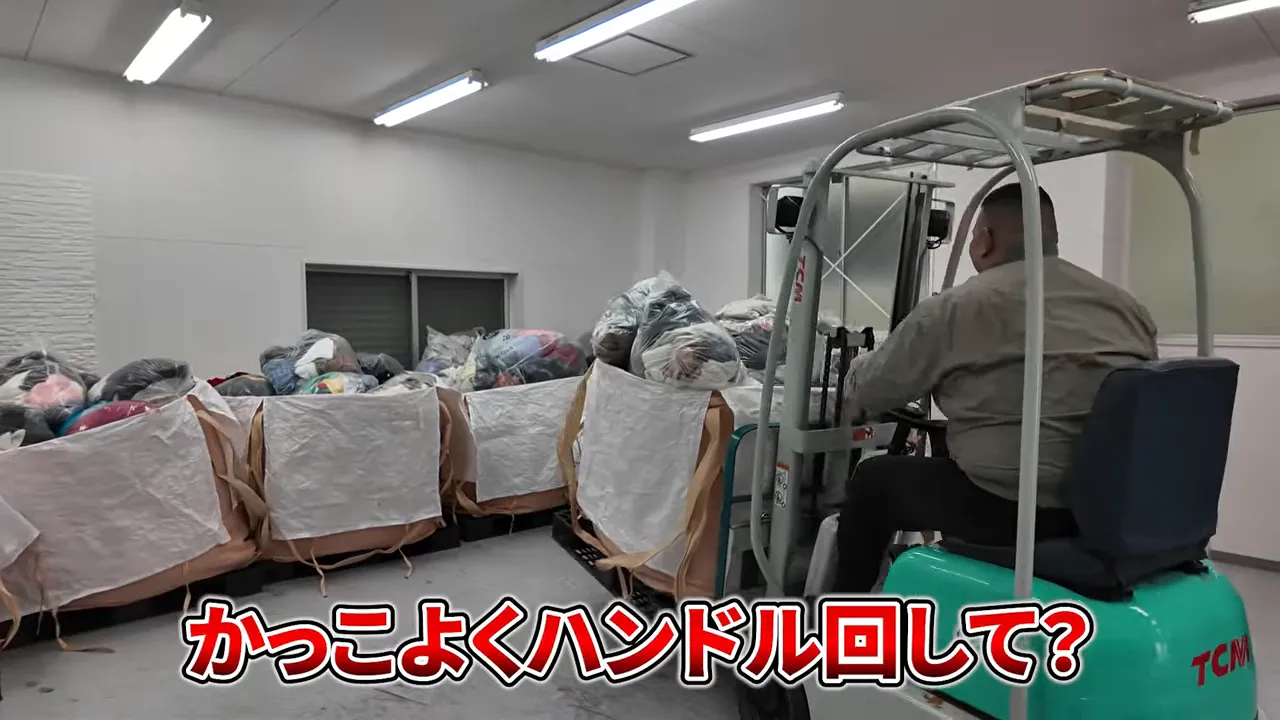 倉庫でフォークリフトが古着の袋を搬入しながら配置している様子