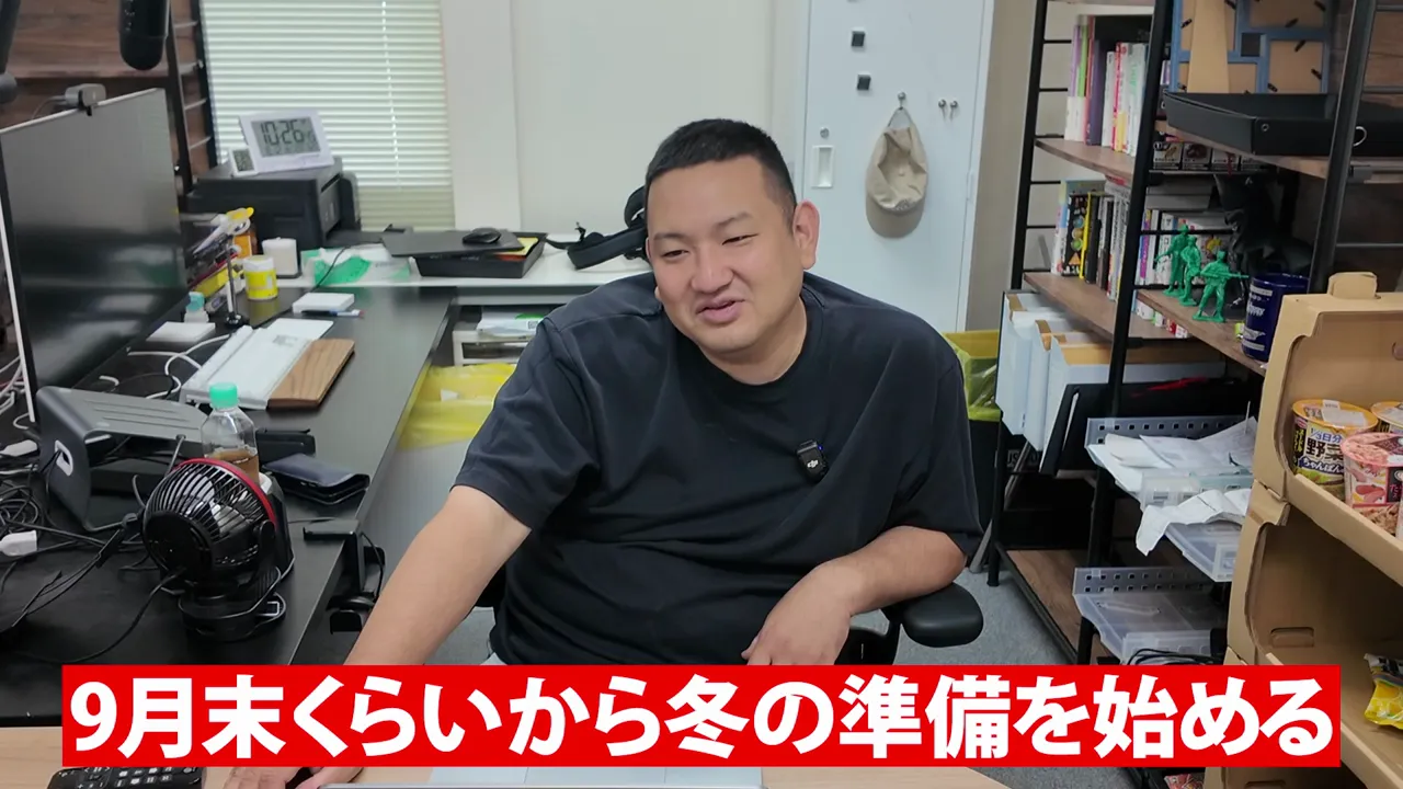 事務所に座る男性と、9月末くらいから冬の準備を始めるという字幕