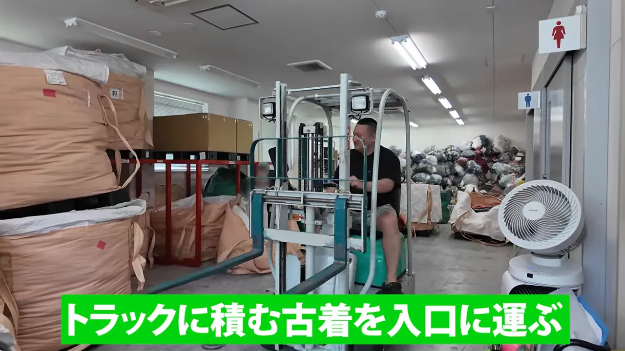 倉庫内で大型の古着バッグをフォークリフトで運ぶ様子