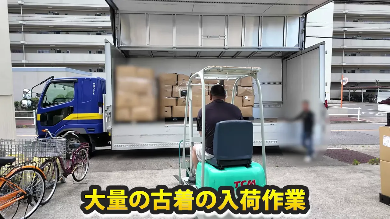 荷台に積まれた段ボール箱をフォークリフトで運ぶ作業風景