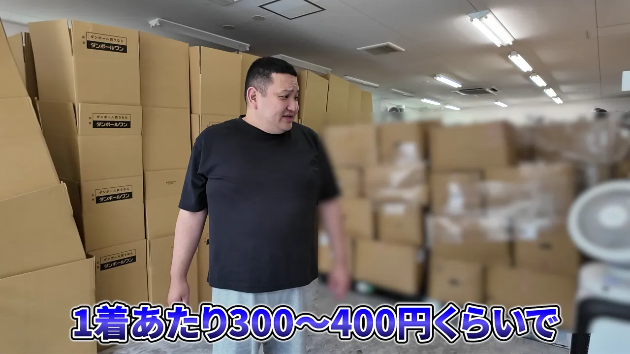 倉庫内に積まれた段ボール箱の前でスタッフが立っている様子
