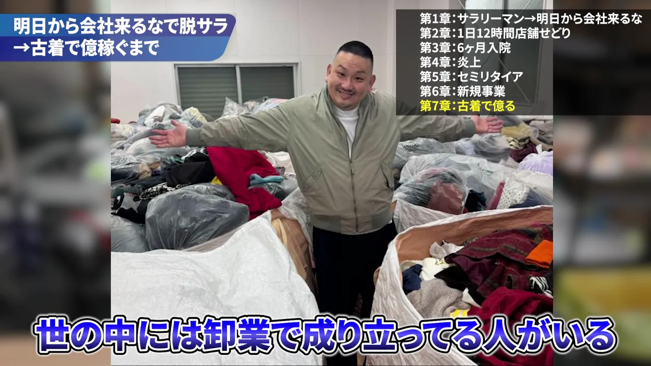 衣類の入った大きな袋が並ぶ場所で両腕を広げる男性の写真