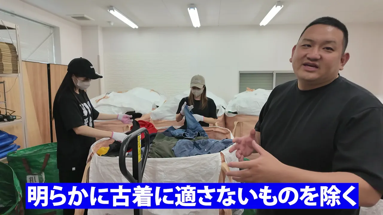 大きな袋に入った衣類をスタッフが確認し、画面下に明らかに古着に適さないものを除くと表示されている様子