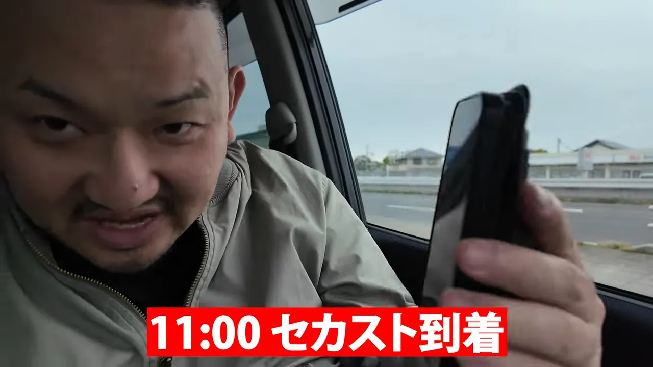 スマホ画面に11:00と表示されセカスト到着のテロップがある車内の様子
