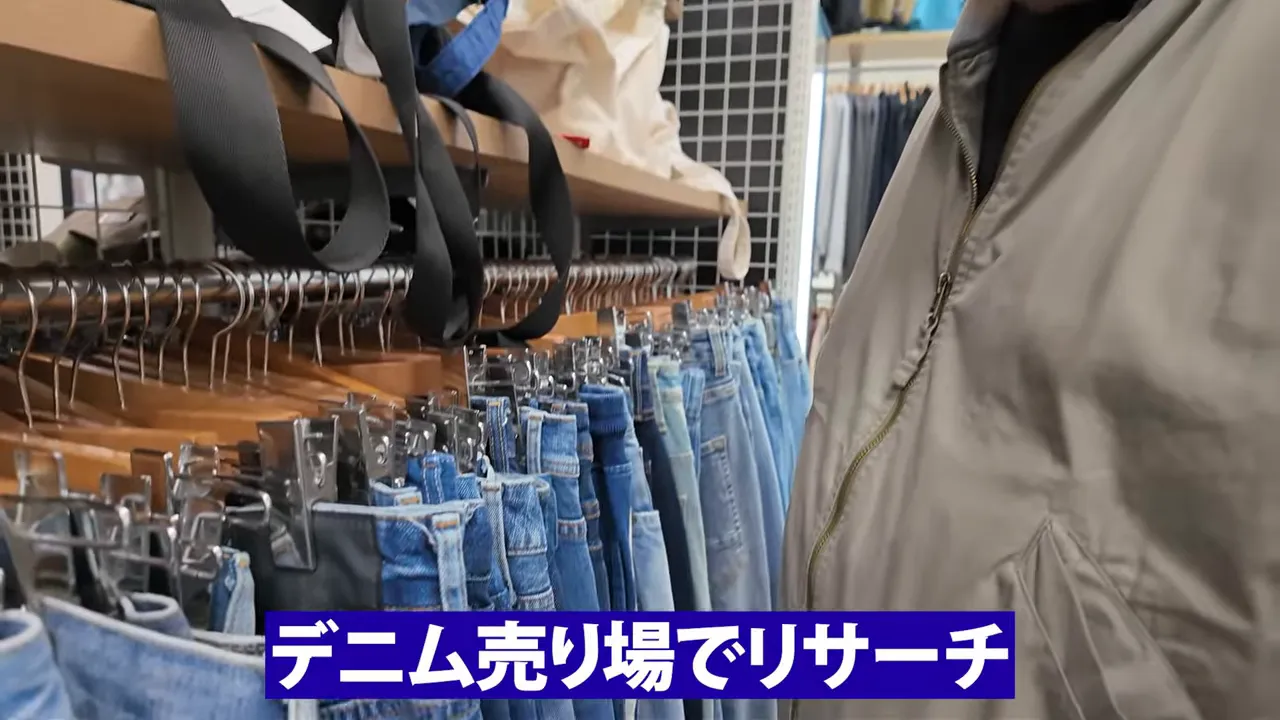 デニム売り場のハンガーラックとデニムを前にリサーチしている様子