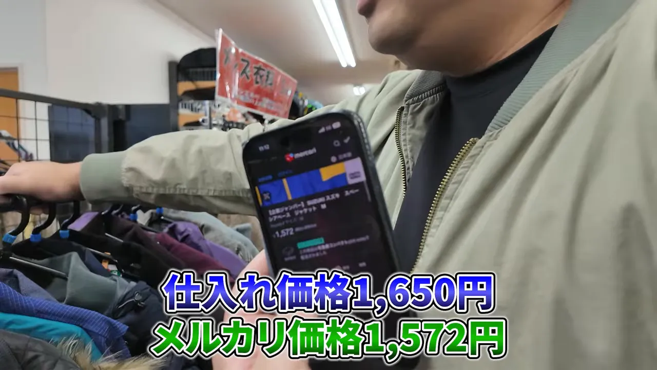 スマホでメルカリの出品画面を見せながら『仕入れ価格1,650円 メルカリ価格1,572円』のテロップが表示された店内の写真