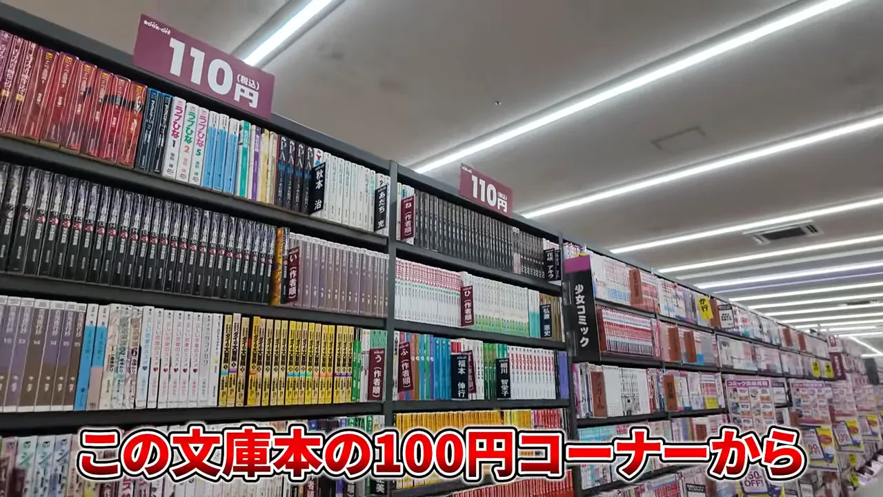 文庫本が並ぶ棚と大きな110円表示の札、100円コーナーの全景が分かる写真