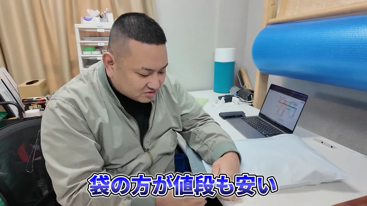 梱包袋を触りながら『袋の方が値段も安い』と説明している場面
