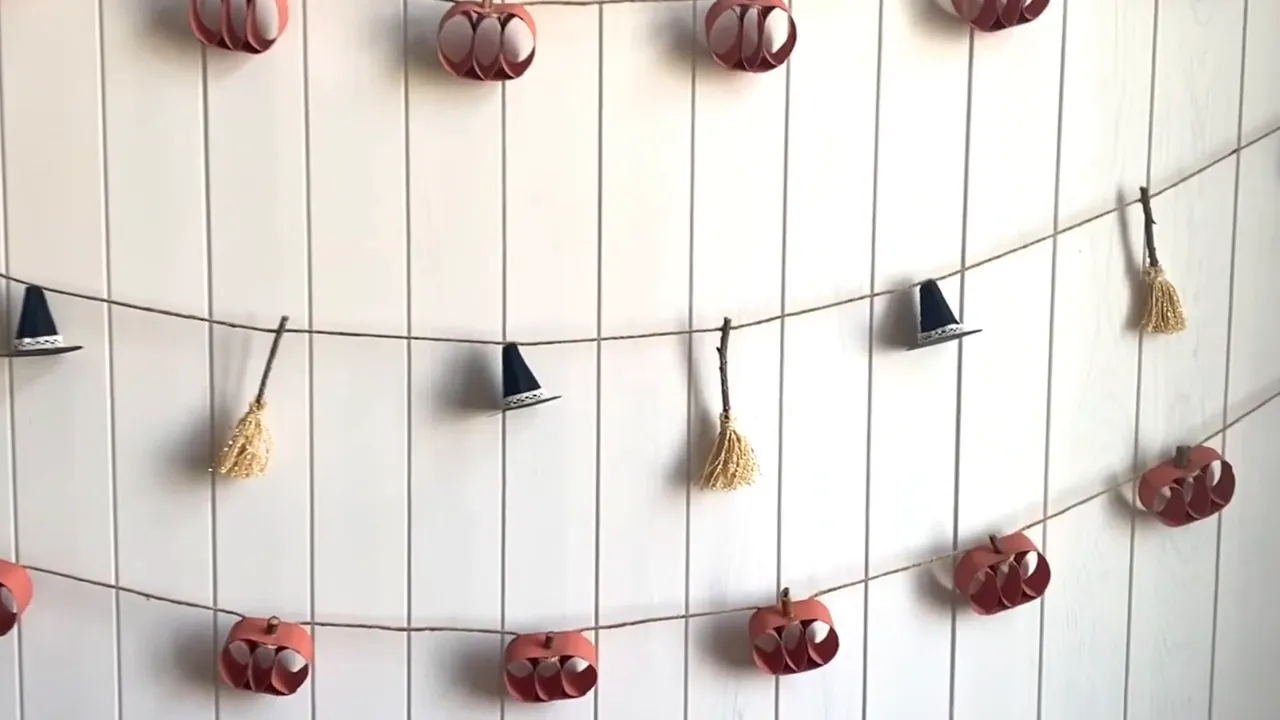 Halloween garland with black witch hats and small twig brooms