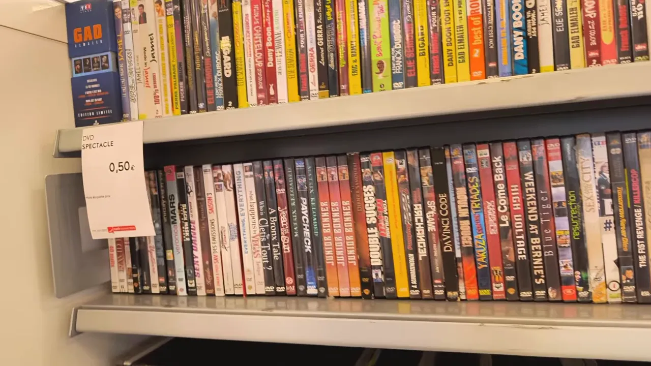 Rayonnage de magasin rempli de DVD avec étiquette de prix visible à 0,50