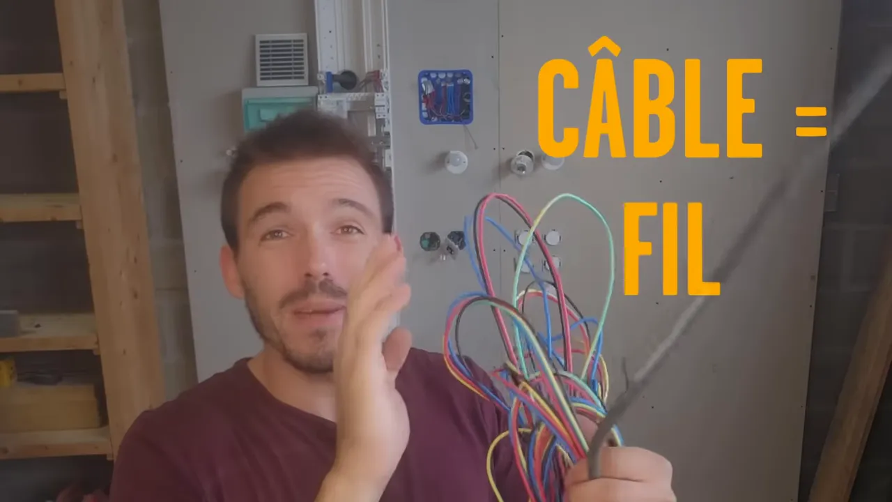 Homme montrant un câble noir et un faisceau de fils multicolores avec texte descriptif à l’écran « CÂBLE = FIL »