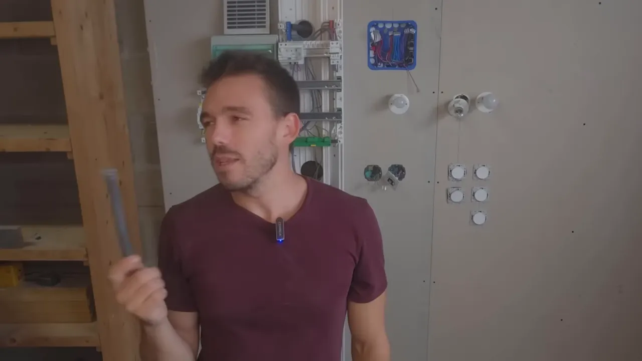 Présentateur tenant une gaine ICTA corruguée devant un panneau de démonstration électrique, démonstration claire de la gaine.