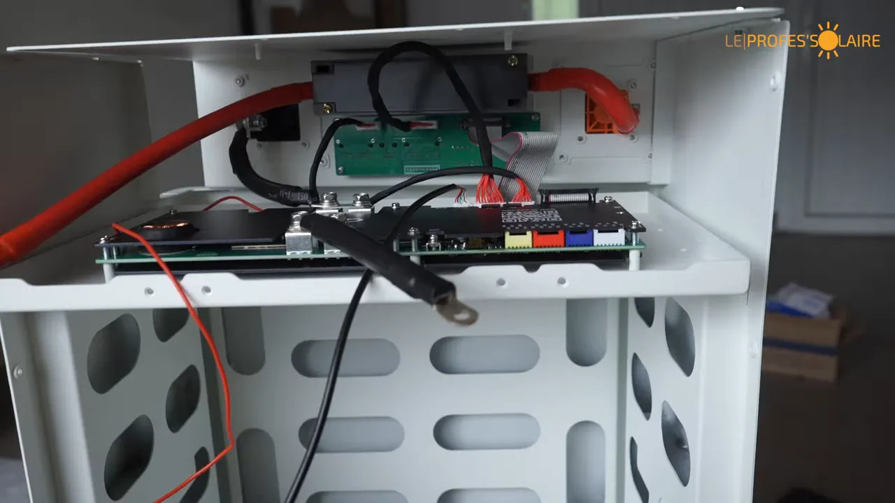 Intérieur du haut du boîtier avec BMS, carte de contrôle, câbles rouges et connecteurs multicolores