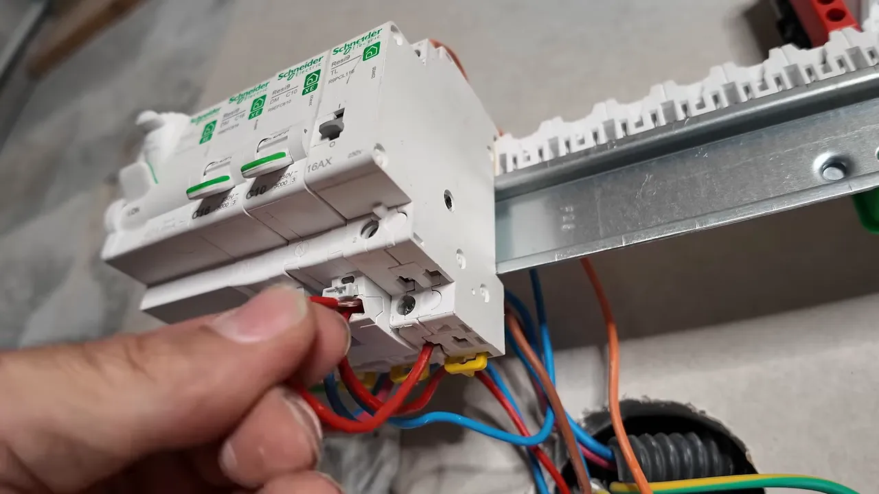 Gros plan sur les bornes d'un télérupteur modulaire et les conducteurs raccordés